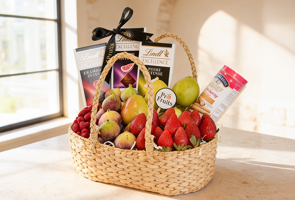 A stylish wicker fruit hamper featuring fresh strawberries, figs, pears, and raspberries paired with  chocolates and wafer rolls for a premium gift.

