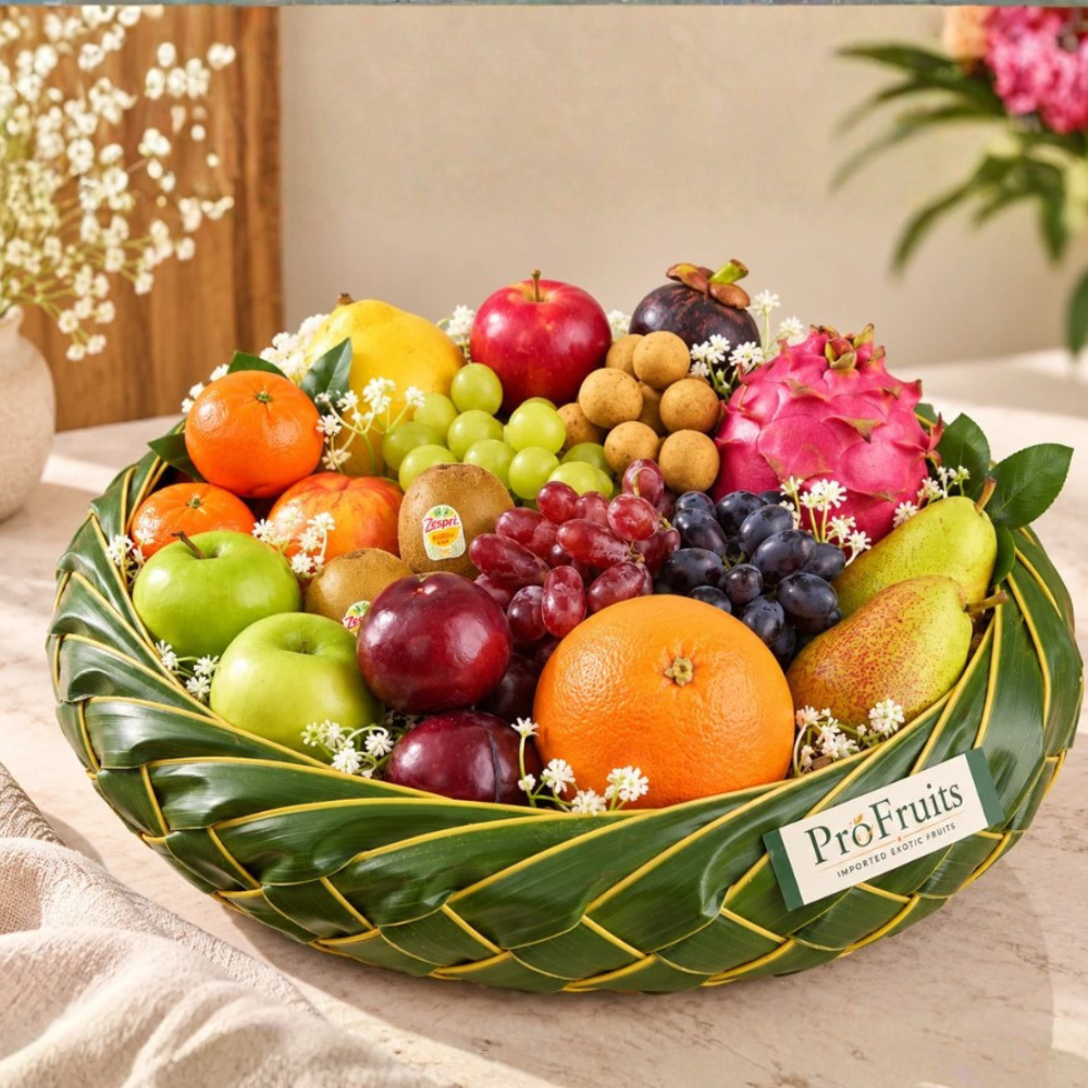 Fruit Hamper filled with fresh apples, grapes, pears, oranges, dragon fruit, plums and other exotic fruits in a woven green basket.
